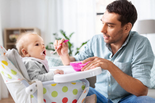 baby eating solids in high chair